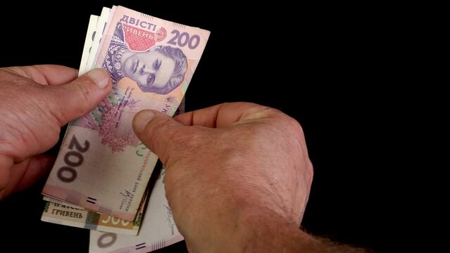 Hands counting stack cash two hundred Ukrainian hryvnia bills, recalculation banknotes.