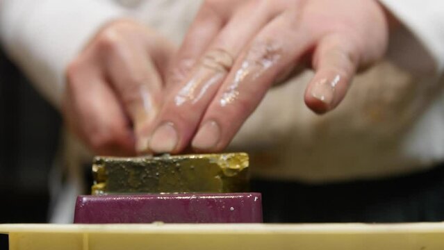 Master swordsmith is sharpening knife on grindstone with water