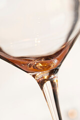 Closeup of the last sip of white wine against a light background with copyspace. Zoom in on an alcohol beverage being enjoyed in celebration. Macro view of style, shape and design of a wine glass