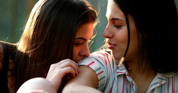 Lesbian girlfriends candid kiss. intimate moment together