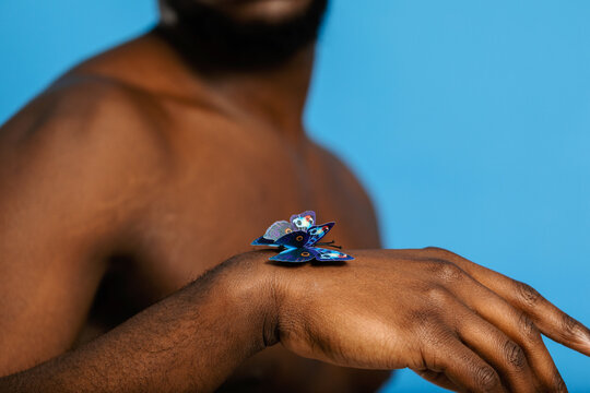 Butterfly perched on black man's arm