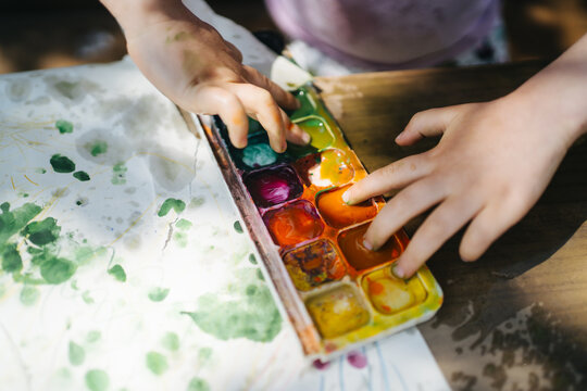 Child's hands and watercolor palette