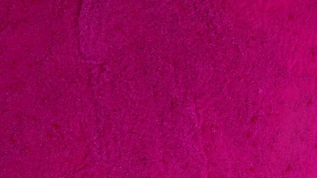 Calm abstract liquid artistic pink background. Shimmering sparkles on a plain fuchsia background.