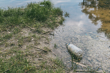 Garbage on the river bank. Pollution of water bodies