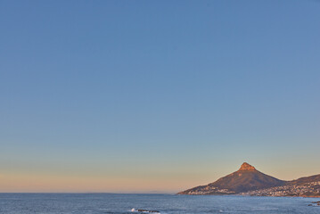 Naklejka na ściany i meble Panorama of table Mountain in Cape Town against a blue sky on a quiet morning with copy space. Banner of clear ocean and views of Lions Head in South Africa. Tranquil, serene, quiet nature in harmony