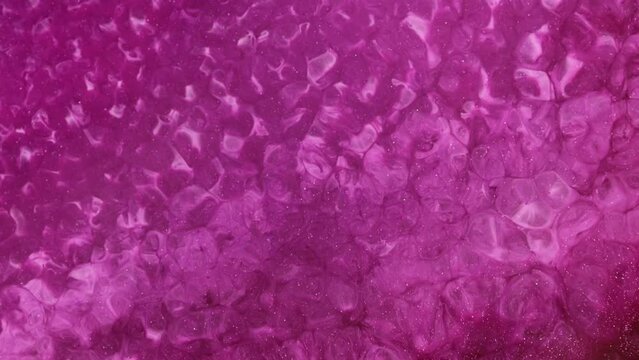 Calm abstract fluid art background. The flow and bubbling of a vivid sparkling pink liquid. 