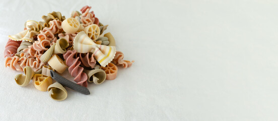 Mix of multi-colored Italian pasta on a light background. Concept alternative pasta. Horizontal orientation. copy space.