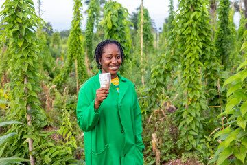 A shot of a happy smiling female African farmer in Nigeria holding some money