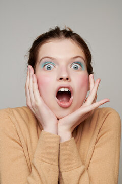 Astonished woman looking at camera in studio
