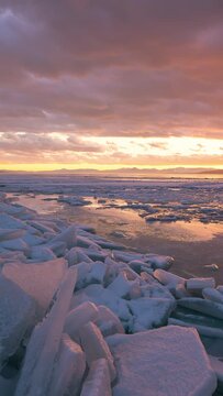 Colorful sunset timelapse over stacks of ice on Utah Lake frozen during winter.