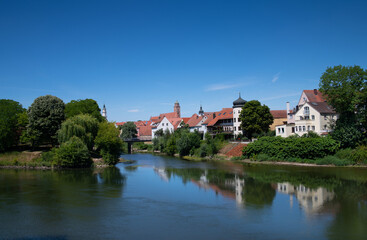 View of the rivers "Donau" and "Wörnitz", which flow together at Donauwörth. In the background the historic city reflected in the water against a blue sky.