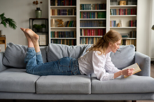 Woman reading book on couch
