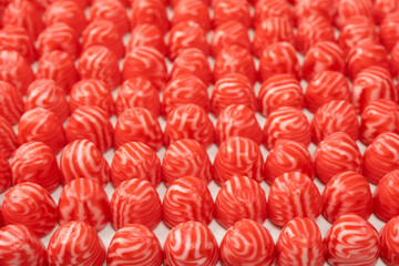 Red round tasty gummy candies as a background.