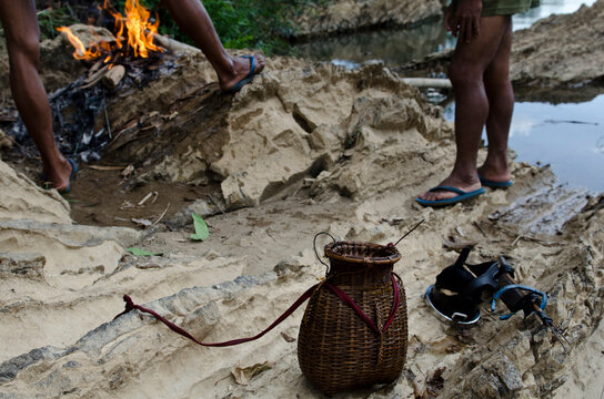 Men start a fire to cook the fish they have caught in Laos
