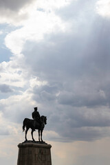 Silhouette of monument of Ataturk with cloudy sky and sunrays between the clouds