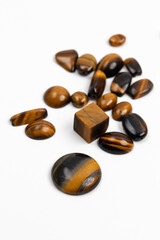 Tigereye. Chatoyant gemstone pieces on white. Rough and polished. Samples from Mineralogy collection