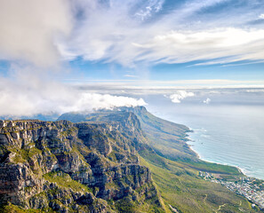 Thick clouds forming on the top of Table Mountain in Cape Town with copy space. Rocky terrain with ocean views, peaceful nature in harmony with soothing view of plants, landscape and bluewater