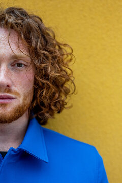 Redhead man with curly hair looking at camera
