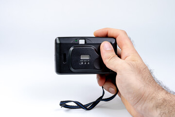 Film camera in hands on a white background