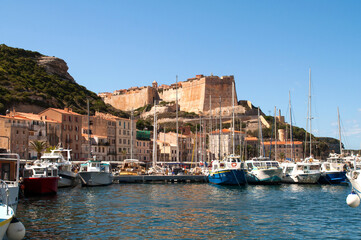 Fototapeta na wymiar Rocks with a castle that rises above the harbor in the town of Bonifacio on the island of Corsica