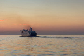 the ferry leaves the harbor at sunset on a warm summer evening