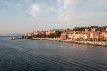 The city of Bastia illuminated by the morning sun, whose buildings and waterfront are reflected in...