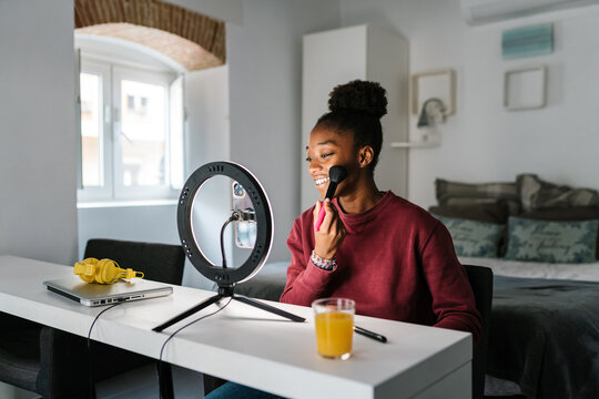 Cheerful black woman recording video for beauty blog
