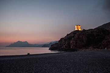 Fototapeta na wymiar Sunset on the beach surrounded by mountains on the island - Porto Ota, Corsica