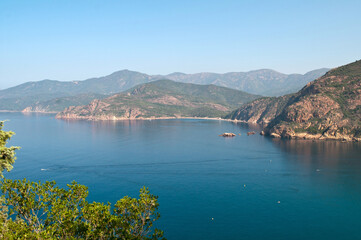 Fototapeta premium View of the sea with sandy beach and the mountains of the typical landscape on the island of Corsica