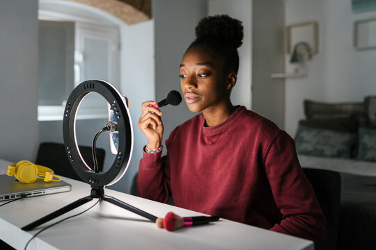 Focused black blogger shooting beauty tutorial
