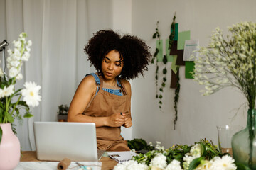 Florist woman looking at her laptop at work