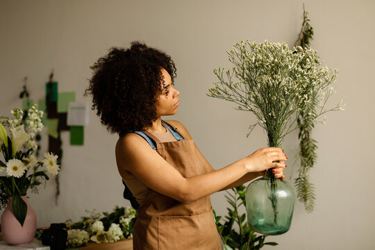 Florist decorating clear carboy with spring flowers