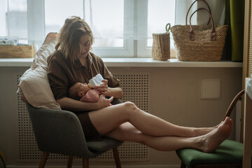 Mother feeding newborn baby with formula