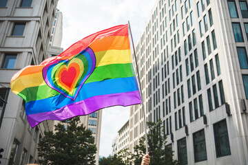 Rainbow Pride flag with a heart waving during Parade in the city