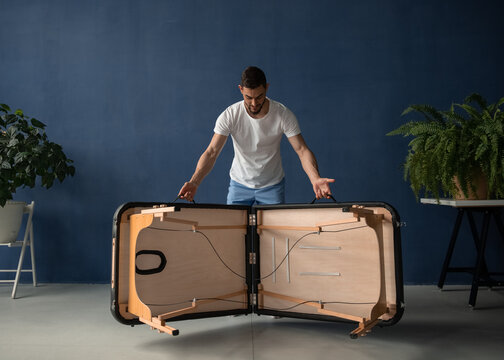 Massage therapist unfolding portable table