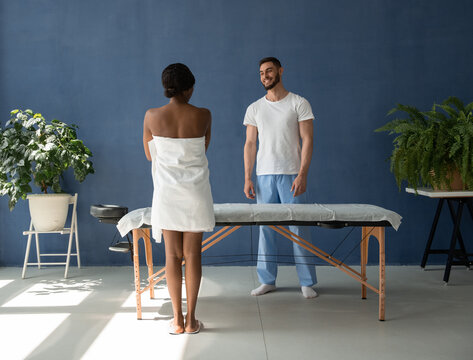 Diverse masseur and client at start of massage session