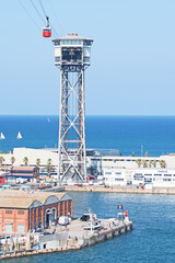 Fototapeta na wymiar A cablecar crosses the port of Barcelona. Officially known as Transbordador Aeri del Port, it is commonly called the 
