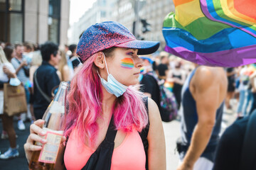 Girl with pink hair and rainbow drawn on a cheek during Pride