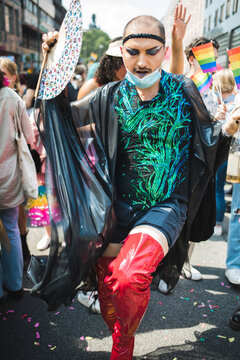Confident man marching in red boots through centra Pride march