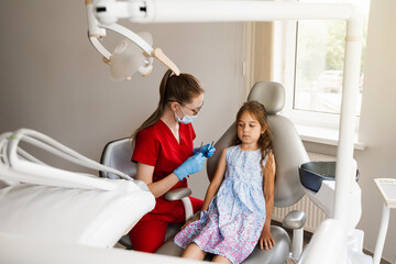 Child girl afraid dentist. Childrens dentist consults frightened kid in dentistry. Treatment of...