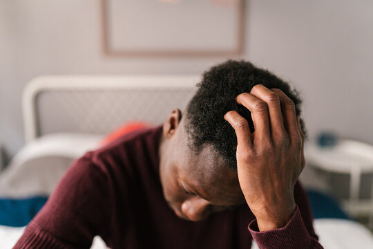 Depressed black man touching curly hair