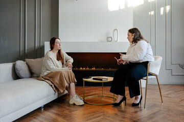 Female psychologist and patient talking during psychotherapy session