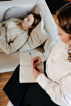 Psychologist making notes in notebook during  session