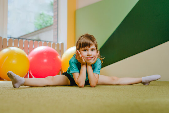 Little girl sitting on the twine looking at camera