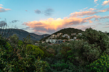 Houses on hillside at sunset