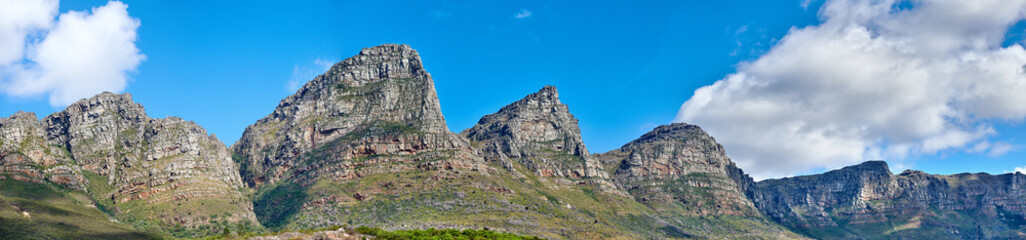 Twelve Apostles at Table Mountain in Cape Town against a blue sky background from below. Breathtaking view of plants and shrubs growing around a majestic rocky valley and scenic landmark in nature