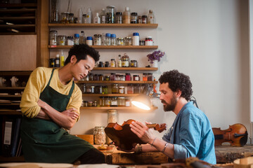 Two violin luthiers discussing about best restoration approach 
