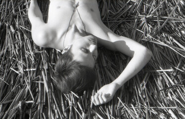 A handsome men lying on a dry grass 