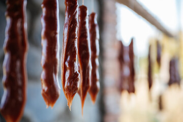 Freshly made homemade churchkhela in Georgia is hung on a stick to cook, harden and be ready to...