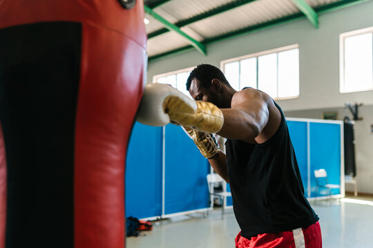 Black boxer punching bag during training